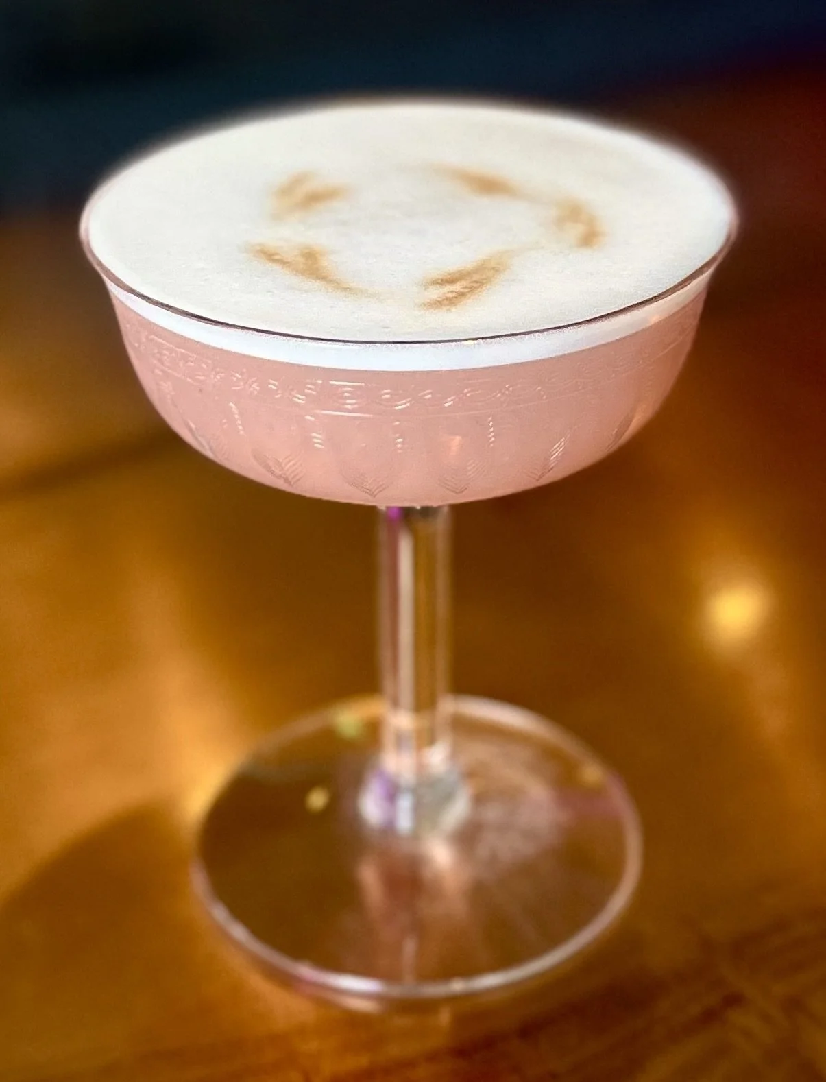 A pink cocktail in a coupe glass