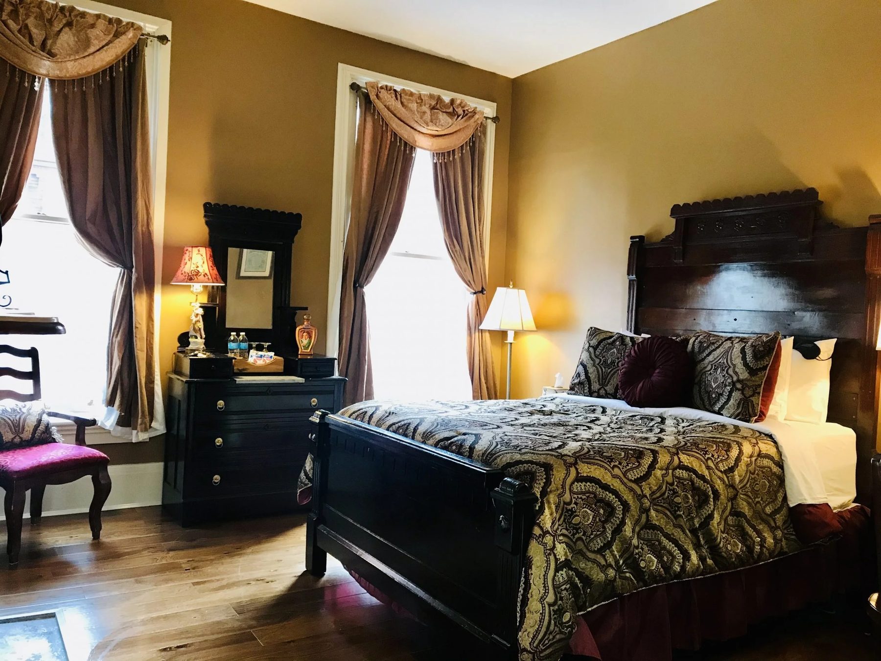The Beethoven Room, with a carved antique headboard and damask bedding